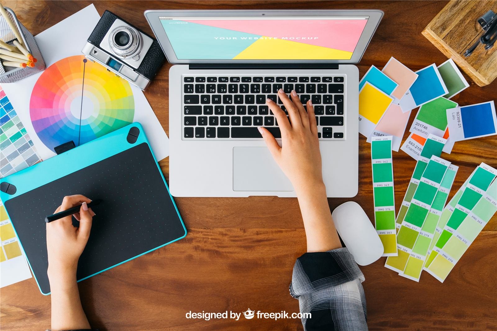 Designer's desk with laptop, drawing tablet and colour swatches